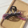 Close-up of a gradient purple bow claw clip with metallic finish on a wooden tray - Purple Gradient