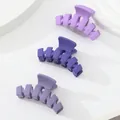 Three matte purple hair claws in light to dark shades on minimalist white pedestals - Large Wave Tooth Style / Purple Series Matte (307E)