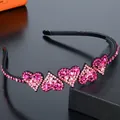 Close-up of pink rhinestone heart embellishments on a black non-slip headband with teeth - Pink