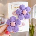 Detail view of two purple knitted flower hair clips on a pink fabric-wrapped BB base - Knitted Texture Style / Purple