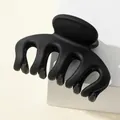 Macro detail of 7cm pumpkin claw clip with matte black frosted finish and five-tooth design - Black