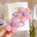 Detail of pink knitted flower hair clips for girls on a white card - Pink