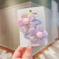 Close-up of a pair of purple mesh flower hair clips with sequins on a branded white card - Purple 2