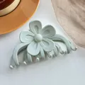 Détail de la pince à cheveux fleur verte mate avec design lisse à cinq pétales sur fond blanc - Vert Morandi