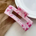 Detail of pink heart pattern claw clip on golden mesh background with white ceramic plate - Pink Heart