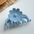 Detail of light blue matte flower hair claw clip with large daisy and sturdy grip teeth - Blue Style Three
