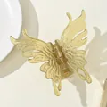 Detailed close-up of a yellow translucent butterfly hair claw with a gold metal spring - Green