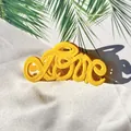Close-up of yellow matte LOVE letter hair claw clip on tropical palm leaf background - Yellow