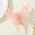 Detailed macro view of a translucent pink butterfly hair claw with golden spring mechanism - Pink