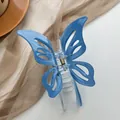 Close-up of light blue butterfly hair claw clip with translucent wings and metal spring - Blue