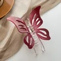 Macro detail of wine red hollow butterfly hair claw clip with transparent base - Red