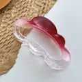 Close-up of a large resin hair claw clip with a red-to-clear gradient and wavy cloud design - Red