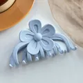 Détail d'une pince à cheveux fleur bleu clair mat avec une finition givrée lisse pour femmes - Bleu Morandi