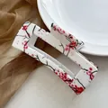 Detailansicht einer großen eckigen Haarklammer mit roten und schwarzen Blumenmustern - Chinesische Pflaumenblüte