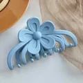 Gros plan d'une pince à cheveux fleur bleu clair mate avec des pétales en résine lisse - Rose bonbon