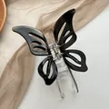 Detail view of hollow butterfly hair claw with black acrylic wings and gold metal spring - Black