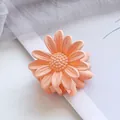 Detailed macro view of 4.5cm matte pink-orange daisy hair claw clip with floral texture - Orange