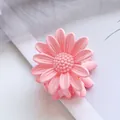 Close-up of small 4.5cm light pink daisy hair claw clip with matte finish texture - Pink