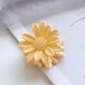 Macro shot of 4.5cm small daisy hair claw clip in matte yellow resin with petal details - Yellow