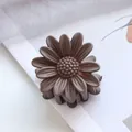 Close-up of 4.5cm daisy flower hair claw clip with matte finish in coffee brown - Dark Coffee