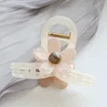 Detalle de pinza para pelo de acetato con flor rosa y resorte metálico dorado - Blanco Roto