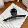 Große Haarklammer in Matt-Schwarz im Halbmond-Design auf einem Holzuntergrund - Balken Schwarz 13CM