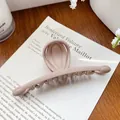 Nahaufnahme einer matten nude-rosa Haarklammer auf einer Karte und Holzoberfläche - Balken Milchkaffee 13CM