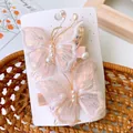 Detailed view of pink embroidered mesh butterfly hair clips with sequins and pearls - Light Pink