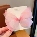 Detailed view of a pink tulle butterfly hair clip on a white branded display card - Pink Bow