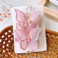 Detail of pink embroidered butterfly hair clips with soft mesh and faux pearl accents - Pink
