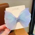 Close-up of a gradient purple and blue mesh butterfly hair clip on a white display card - Blue Bow