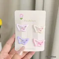 Close-up of four colorful 3cm hollow butterfly hair clips held in hand for size detail - Butterfly