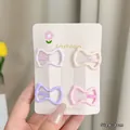 Four 3cm macaron-colored bow hair clips displayed on a floral fashion card - Bow