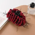 Detail view of large dark red satin hair claw with black feather trim and bow embroidery - Dark Coffee