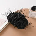 Close-up of black fabric hair claw clip with elegant feather trim on leather surface - Black