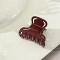 Dettaglio dell'elegante pinza per capelli a farfalla bordeaux con finitura lucida - Stile Base Caffè Chiaro