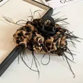 Dettaglio di un grande fermaglio per capelli leopardato con finiture in piume nere - Leopardo Fulvo Classico / Cuoio