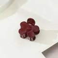 Détail d'une pince à cheveux fleur bordeaux brillant sur un support géométrique - Style Fleur / Bordeaux