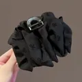 Dettaglio della molletta per capelli in raso nero con fiocchi ricamati e molla in metallo - Nero