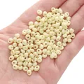 Creamy beige 5x5mm glass beads for DIY jewelry making held in palm for scale - 10g/Pack (Approx. 100 Beads) / Light Yellow