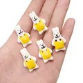 White ceramic bunny buttons with yellow aprons held in hand for size comparison - Yellow Bib Rabbit