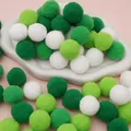 Green and white Christmas pom-poms craft supplies for DIY holiday decor on pink surface - 30Pcs Pack / 2.5cm / Green Series