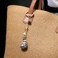 Golden keychain with natural cone shell, black lava stone and palm tree charm on tote bag - Palm Tree Conch Style (HWBC766-1)