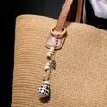 Bohemian gold keychain with spotted cone seashell and beads on a leather bag handle - Hwbc766-2
