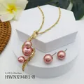Elegante gouden slangketting en roze pareloorbellen set op witte geometrische stands - Roze