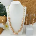 Detailopname van goudkleurige sieradenset met roze schelpparels op een display - Roze-Oranje (HWNX9385-6)