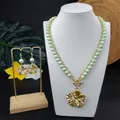 Detail of gold hibiscus flower jewelry set with green pearls on a white neck bust - Light Green (HWNX9344-4)