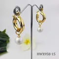 Detail of 18K gold-plated hoop earrings featuring natural shell pearl on a display stand - White Pearl Style (HWX958-15)