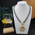 Detail eines Plumeria-Schmucksets mit grauen Perlen und kristallbesetzten Goldblüten - Grau (HWNX9344-8)
