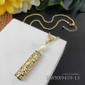 Close-up van de gouden holle hanger met bloempatroon en wit pareldetail aan de ketting - Witte Parel Stijl (HWNX9459-13)
